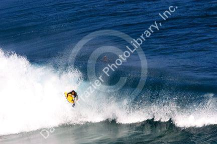 Boogie boarding on waves in the pacific ocean off the island of Maui, Hawaii.