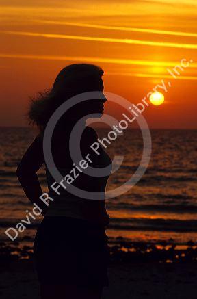 A woman silhouetted at sunset on the Florida Gulf Coast.