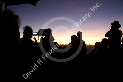 Tourists using digital cameras await the sunrise atop Mount Haleakala on the island of Maui, Hawaii.