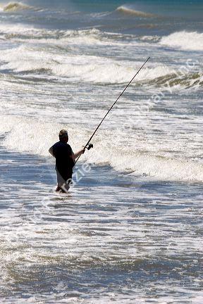 Fisherman surfcasting in the ocean near Miramar Argentina.