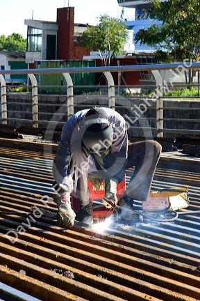 Construction worker welding on bridge deck in Buenos Aires, Argentina.
