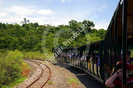 Passengers ride on the Green Train of The Jungle at Iguazu Falls, Argentina.