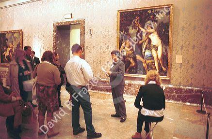Interior of the Prado art museum showing paintings and visitors.
