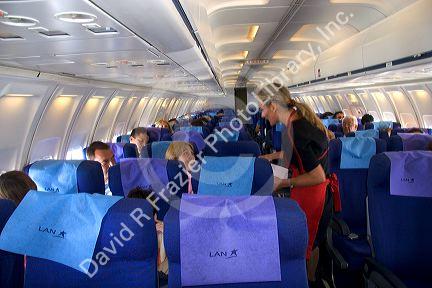 Flight attendant speaking to a passenger on an airplane.
