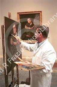 Artist painting a copy in the Prado art museum in Madrid, Spain.