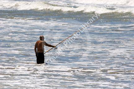 Fisherman surfcasting in the ocean near Miramar Argentina.