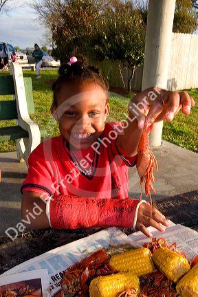 African american girls eating crawfish and corn on the cob in New Orleans, Louisiana.