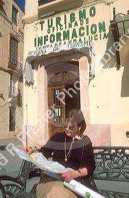 Female traveler outside tourist office in Ronda, Spain.