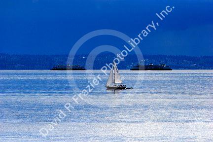 Sailboat and ferries in Puget Sound near Seattle, Washington with thunderstorm in background.
