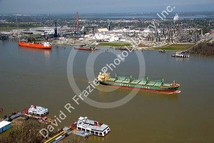 Bulk material ship on the Mississippi River near New Orleans, Louisiana.  Also ferry boats and tankers at refinery.