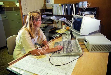 Cartographer, highway department map maker on a computer in Boise, Idaho.