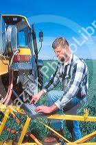 Farmer using a laptop computer in the field to calculate and record chemical spray application.