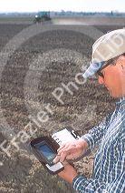 Farmer uses a palm pilot, (PDA) to record chemical use in the field.