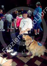 Hanicapped man in a wheelchair uses helper dog to complete tasks he can not do himself.