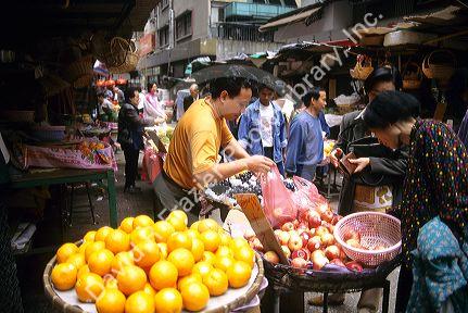 People shop at a traditional produce market in Hong Kong.