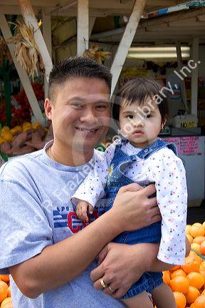 Asian father and daughter at a roadside fruit stand in Morgan Hill, California.