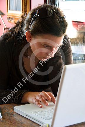 A woman using a laptop computer in a coffee shop, Boise, Idaho. MR