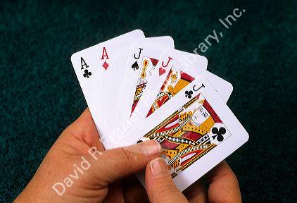 A poker hand of playing cards showing a full house.