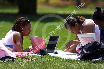 African american female students study using laptop computers on the lawn of Albion College in Michigan.
