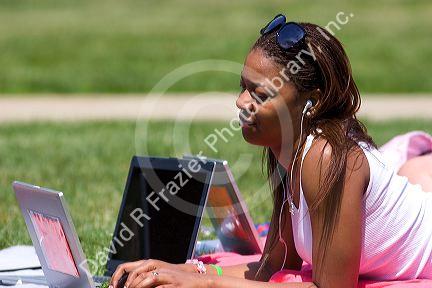 African american female students study using laptop computers on the lawn of Albion College in Michigan.