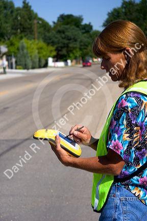 A woman using a handheld GIS device in the field, Boise, Idaho.