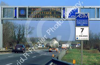 Speed limit signs change with conditions along Autostrada near Milan, Italy.