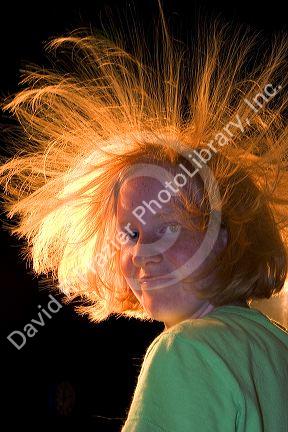 Girl with hair standing on end do to static electricity from a Van de Graaff Generator at the Discovery Center in Little Rock, Arkansas.