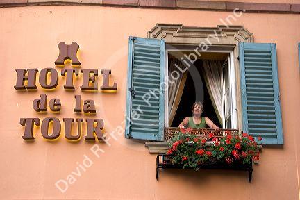 A woman in the window of the Hotel de la Tour in the village of Ribeauville, Eastern France.