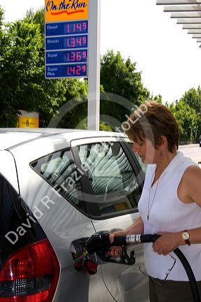 Woman fueling a car at a gas station in Friesing, Germany. MR