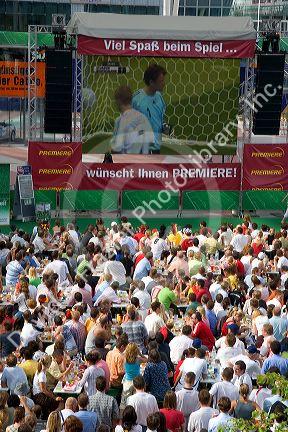 A crowd outdoors at the Munich airport watch a 2006 World Cup match on big screen televisions, Germany.