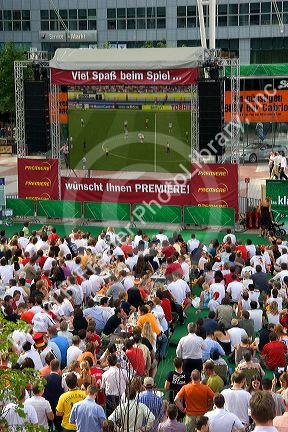 A crowd outdoors at the Munich airport watch a 2006 World Cup match on big screen televisions, Germany.