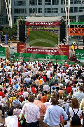 A crowd outdoors at the Munich airport watch a 2006 World Cup match on big screen televisions, Germany.