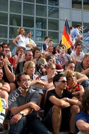 A crowd of soccer fans gather outdoors at the Munich airport watch a 2006 World Cup match on big screen televisions, Germany.