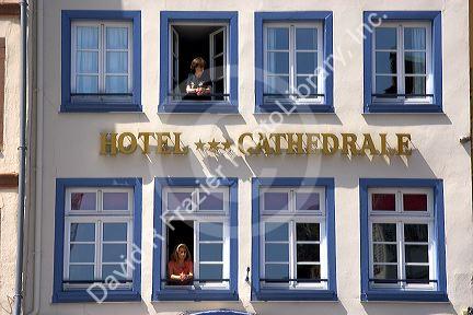 Women looking out the window of the Cathedral Hotel at Strasbourg, France.