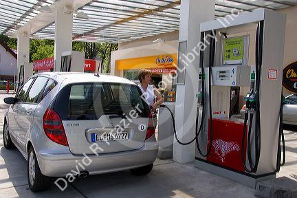 Woman fueling a car at a gas station in Friesing, Germany. MR