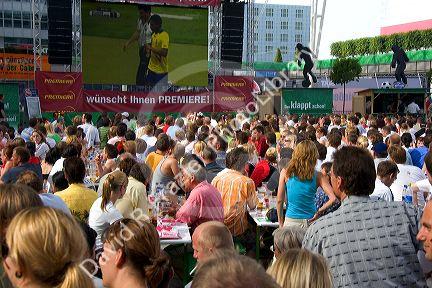 A crowd outdoors at the Munich airport watch a 2006 World Cup match on big screen televisions, Germany.