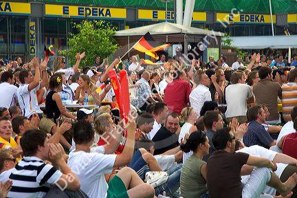 A crowd of soccer fans gather outdoors at the Munich airport watch a 2006 World Cup match on big screen televisions, Germany.