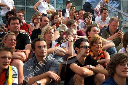 A crowd of soccer fans gather outdoors at the Munich airport watch a 2006 World Cup match on big screen televisions, Germany.
