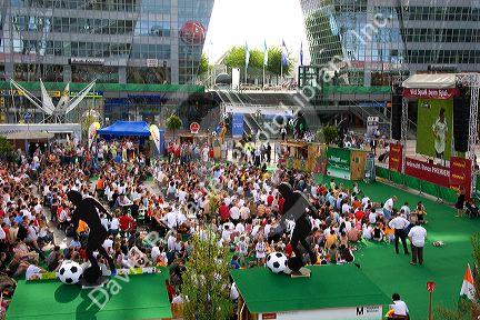 A crowd of soccer fans gather outdoors at the Munich airport watch a 2006 World Cup match on big screen televisions, Germany.