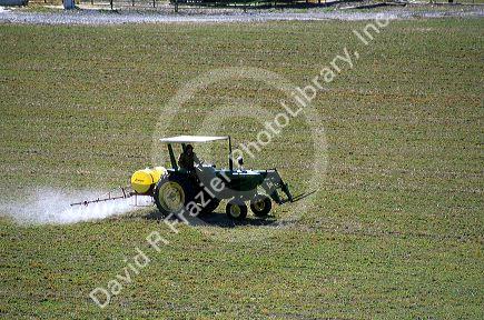 Tractor spraying herbicide on a field.