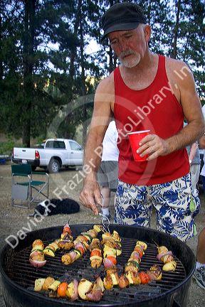 Campers preparing shish kabob meal.