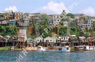 Housing in Manaus Brazil along the Amazon River also showing riverboats and native vegetation.  River level fluctuates as much as 50 feet during rainy season.