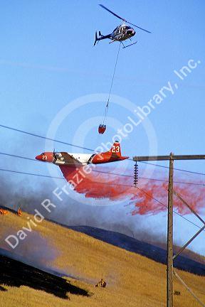 A  P-3 Orion fire bomber dropping retardant and a helicopter dropping water on a wildfire in Idaho.