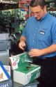 Radio Shack employee using a battery disposal unit.