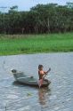 Brazillian boy rows a canoe on a tributary of the Amazon River in Manaus, Brazil.