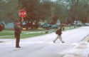 School crossing guard with child walking on crosswalk. MR
