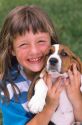 Young girl holding a basset hound puppy.