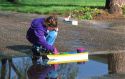 Seven year old girl floating a home made model boat.  MR