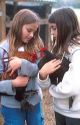 Young girls holding a pet hen and a rooster.  MR