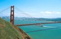 Cargo ship passing beneath The Golden Gate Bridge in San Francisco, California.
